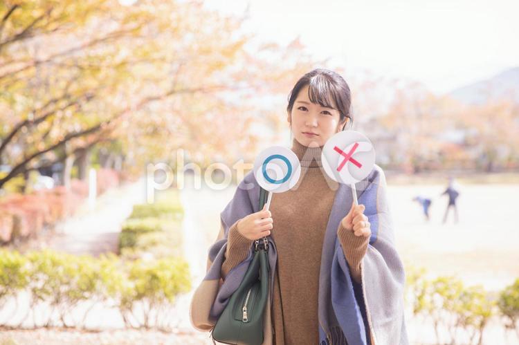 秋の公園でバツを作る女性 バツ,ダメ,秋の写真素材