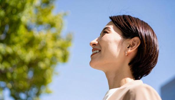 上を向いた日本女性の笑顔の横顔 上を向いた日本女性の笑顔の横顔の写真