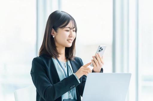 スマホを使う笑顔の女性・ビジネスウーマン スマホを使う笑顔の女性・ビジネスウーマン 女性,スマホ,スマートフォンの写真素材