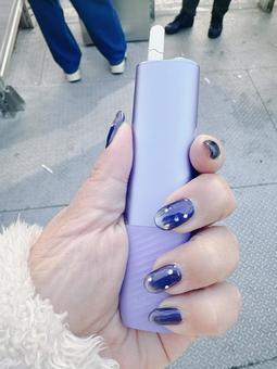 アイコスを持つ女性 アイコスを持つ女性 アイコス,電子タバコ,ネイルをした女性の写真素材