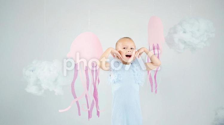 カメラ目線でポーズする女の子とクラゲの装飾 女の子,笑顔,ポーズの写真素材