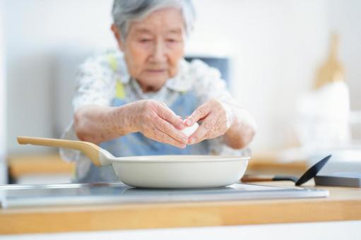 真剣な顔で卵を持つ高齢女性 女性,卵,持つの写真素材