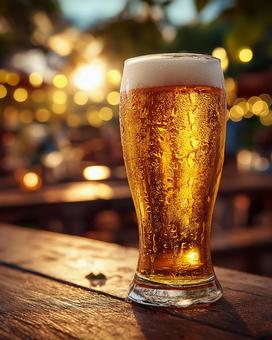 テーブルに置かれた、黄金色のビールグラス テーブルに置かれた、黄金色のビールグラスの写真