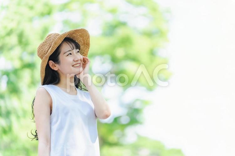 夏に麦わら帽子を被る女性（紫外線対策） 夏,女性,紫外線の写真素材