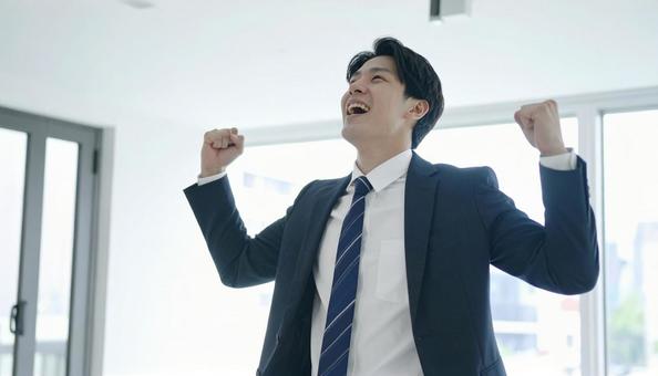 オフィスで喜ぶビジネスマン オフィスで喜ぶビジネスマンの写真