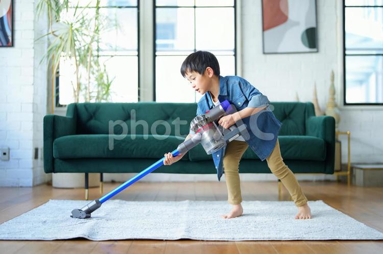 腰を入れて掃除する男の子 男の子,小学生,リビングの写真素材