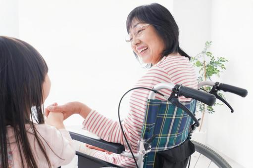 車椅子に乗るおばあちゃんと女の子 散歩,保険,病院の写真素材