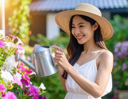 夏の朝・花に水やりする彼女の写真