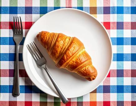 クロワッサンとカラフルなテーブルクロスの写真