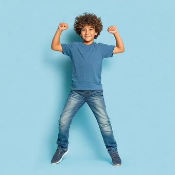 勝利のポーズをとる、無邪気な少年の写真