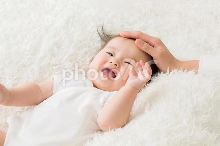 女性に撫でられる赤ちゃん（笑顔） 赤ちゃん,なでる,母親の写真素材