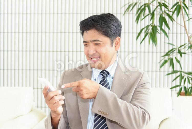 スマートフォンを持つ笑顔の男性 男性,男,笑顔の写真素材