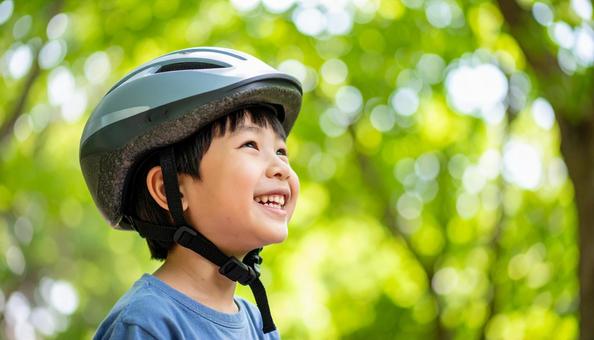 自転車用ヘルメットをかぶる男の子 自転車用ヘルメットをかぶる男の子の写真