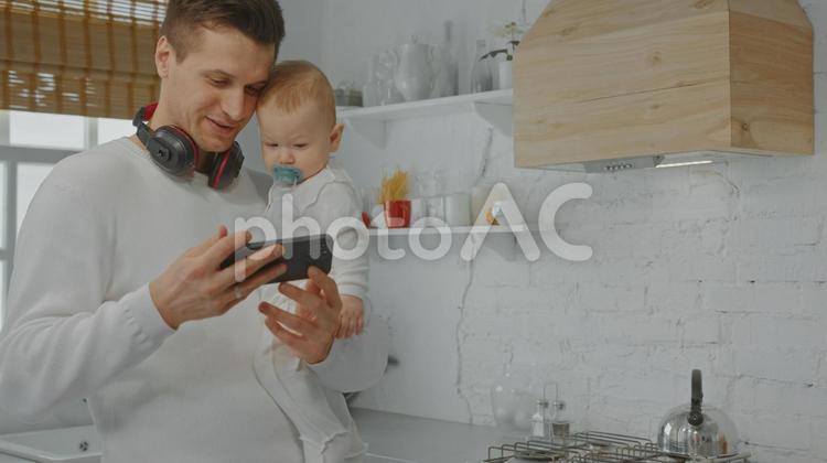 スマホ画面を赤ちゃんに見せているお父さん 男性,お父さん,赤ちゃんの写真素材