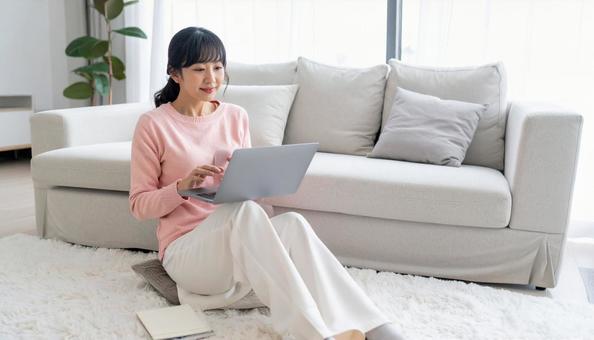 PCから投資をするオシャレな大人女性の写真