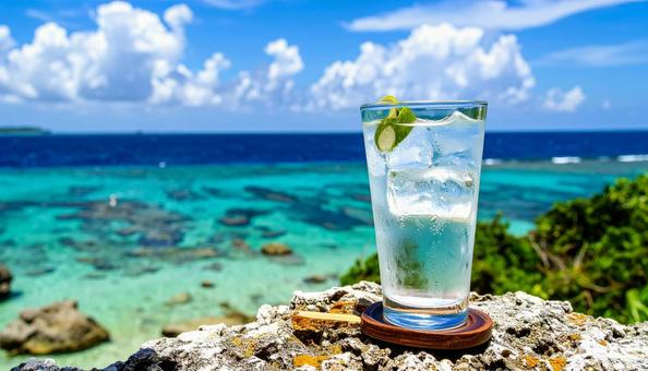 青い海を背景のグラスに注がれた泡盛の写真