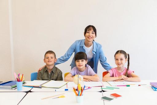 カメラ目線の女性と生徒たち 女性,女の子,男の子の写真素材
