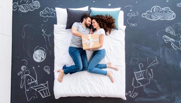 ギフトボックスを枕にして眠るカップル ギフトボックスを枕にして眠るカップルの写真