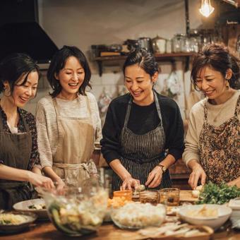 4人の女性たちが一緒に料理するキッチン 4人の女性たちが一緒に料理するキッチンの写真