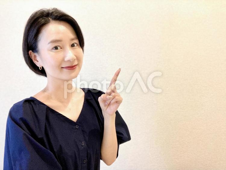 笑顔で指をさすショートヘアの女性 ビジネス,ナンバーワン,ビジネスウーマンの写真素材