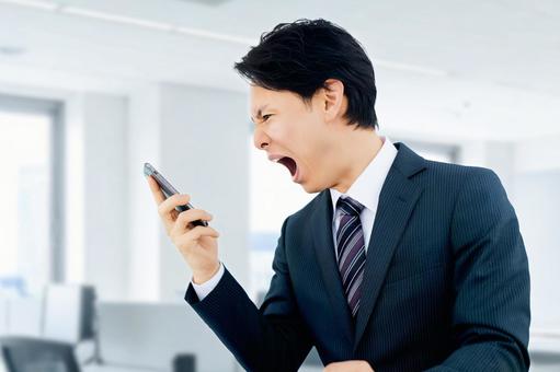 スマホに向かって大声で怒るビジネスマン 男性,スマホ,ビジネスの写真素材