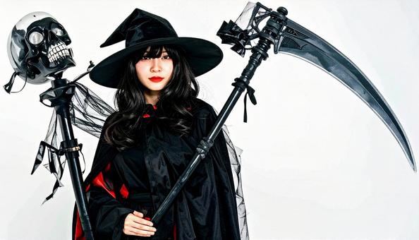 鎌を持った魔女に仮装する女性 ハロウィン 鎌を持った魔女に仮装する女性 ハロウィンの写真