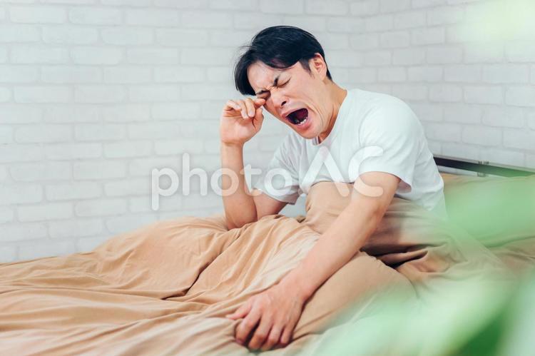 ベッドルームにいる男性(起きる) ベッドルームにいる男性(起きる) 眠い,不眠症,睡眠不足の写真素材