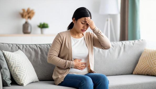 肥満で疲れやすく、額に手をやる女性 肥満で疲れやすく、額に手をやる女性の写真