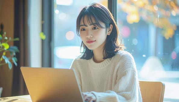 カフェでノートパソコンを使う日本人女性 カフェでノートパソコンを使う日本人女性の写真