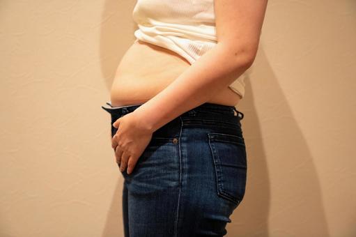 デニムパンツにのったお腹周りの脂肪 ダイエット,セルライト,脂肪燃焼の写真素材