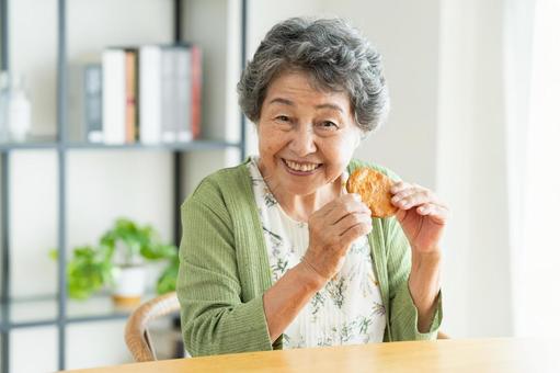 せんべいを食べるシニアの女性 せんべいを食べるシニアの女性 せんべい,煎餅,固いの写真素材