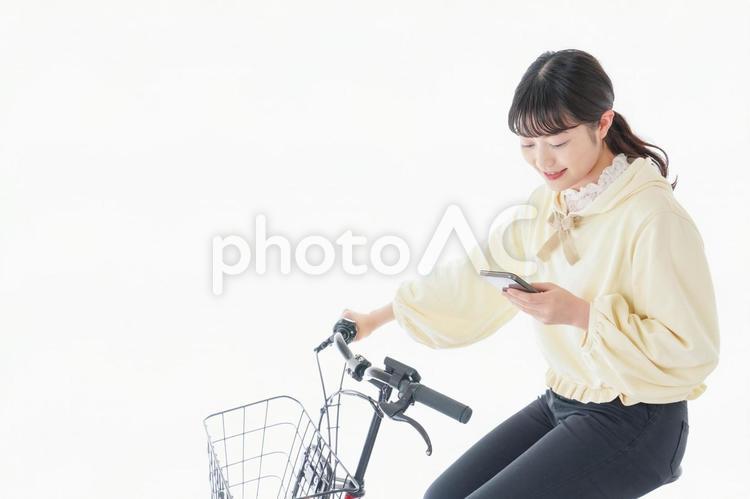 自転車でスマホを使う若い女性 交通マナー,女性,車道の写真素材