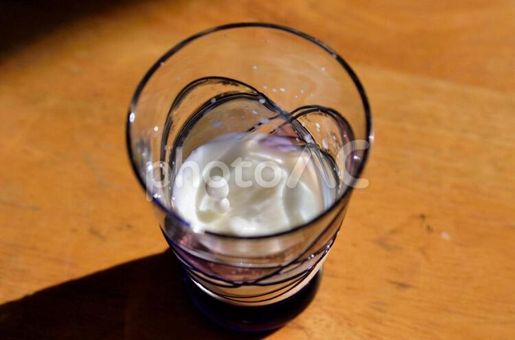 コップに入った牛乳に牛乳を一滴たらしたところ1 ガラス,グラス,テーブルの写真素材
