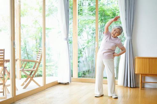 腰に手をあて腕を伸ばす女性 女性,体操,真顔の写真素材