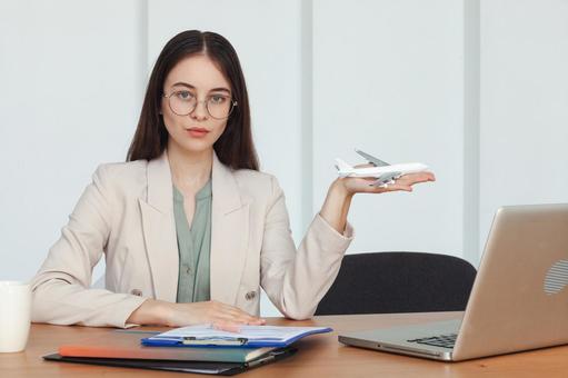 飛行機の模型を手に持った女性スタッフ 事務職,接客業,アドバイザーの写真素材