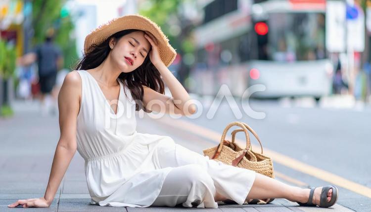 暑さでダウンし、路上に倒れる女性 ダウン,倒れた,女性の写真素材
