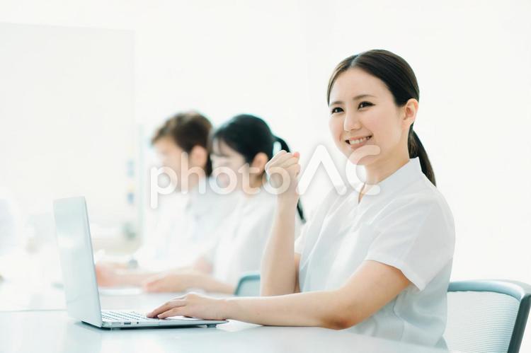 白衣・ナース服を着た女性（ガッツポーズ） 看護師,ナース,介護士の写真素材
