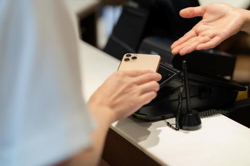 ショッピングをしてモバイル決済をする女性 モバイル決済,ショッピング,買い物の写真素材