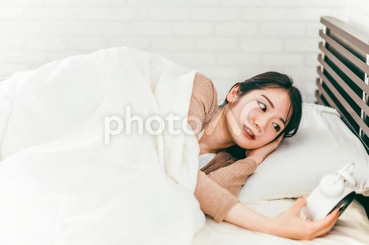 寝坊して目覚まし時計で起きる女性（遅刻） 寝坊,遅刻,アラームの写真素材