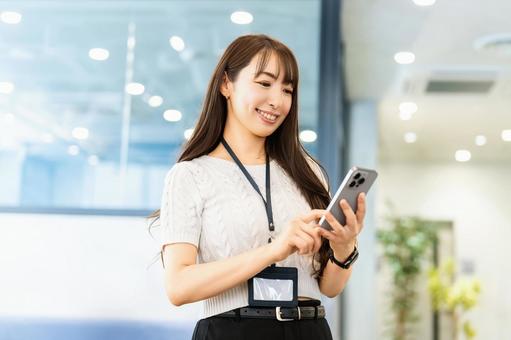 スマホを使う笑顔の女性・ビジネスウーマン 女性,スマホ,スマートフォンの写真素材