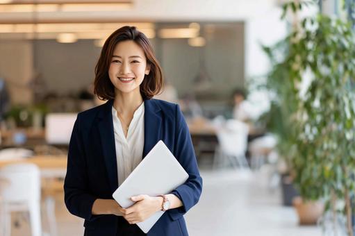 オフィスで微笑む女性社員 オフィスで微笑む女性社員の写真