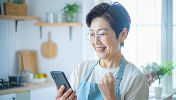 スマホでポイ活する笑顔の女性 スマホでポイ活する笑顔の女性の写真
