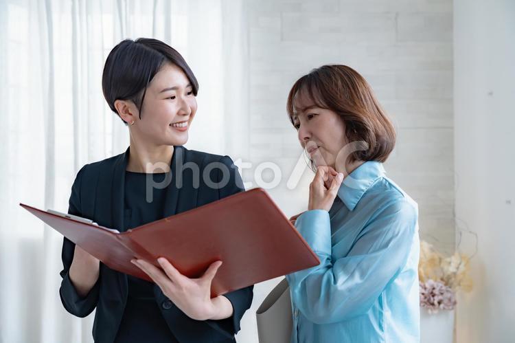 シニア女性とスーツを着た女性 レシェプション,受付,ビジネスウーマンの写真素材