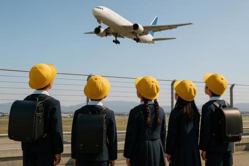空港の展望デッキで飛行機を見上げる小学生 空港の展望デッキで飛行機を見上げる小学生の写真