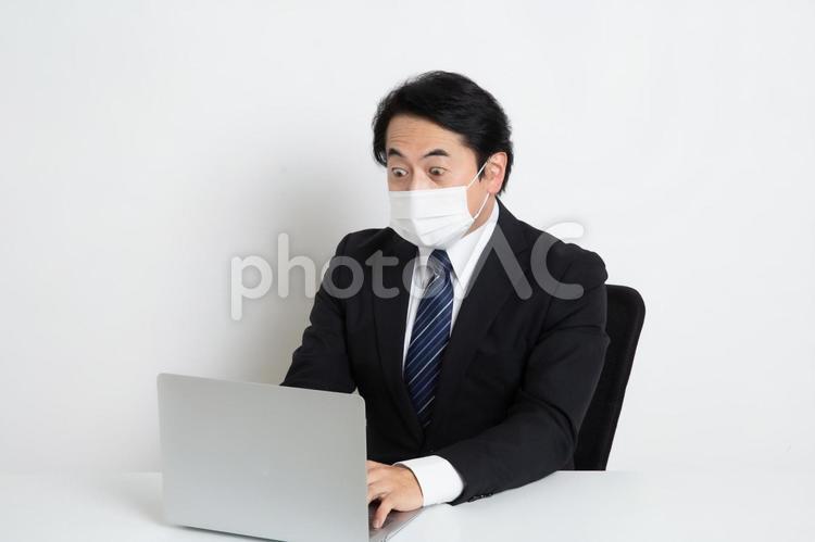 トラブルに気付いたマスクをしている中年のサラリーマン男性 中年,上司,会社員の写真素材