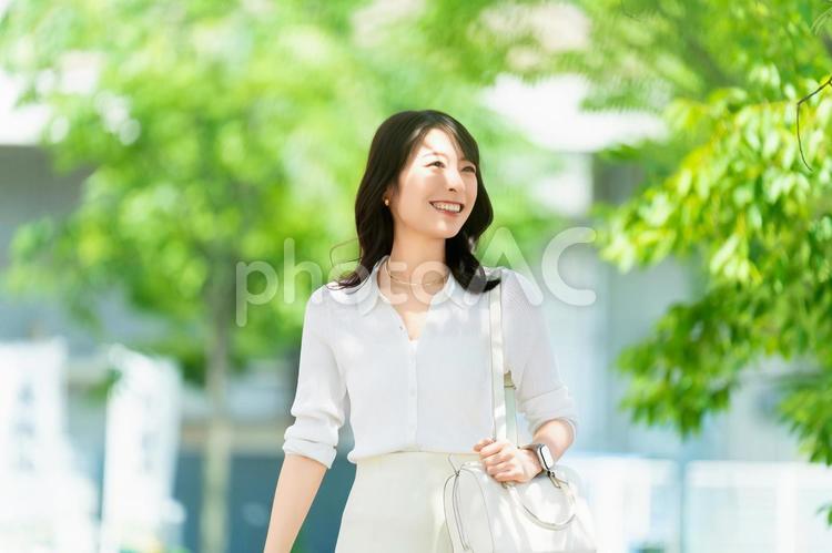 屋外を歩く笑顔の女性・ビジネスウーマン 女性,歩く,夏の写真素材