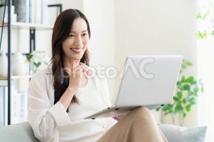リビングでテレワークをする若い女性 女性,パソコン,テレワークの写真素材