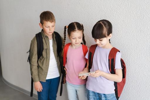 携帯を見る生徒たち 男の子,女の子,子どもの写真素材