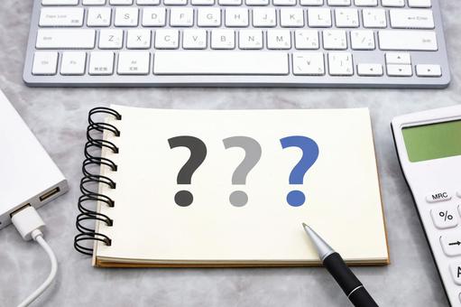 机の上のノートとクエスチョンマーク 疑問,なぜ,はてなの写真素材