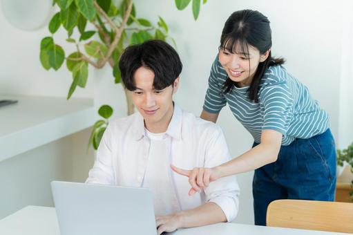パソコンを見るカップル ノートパソコン,笑顔,カップルの写真素材